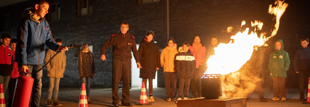 Bild aus einem Feuerwehrkurs. Kinder üben das Feuerlöschen